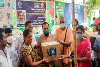 A Happiness Kit is being handed over to a child’s parent